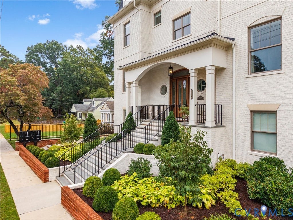 511 Libbie Avenue, #A, The Row At Westhampton, Richmond, VA 23226 White brick exterior with a columned portico, a wood-paneled entry door, and a multi-tiered staircase featuring black metal railings