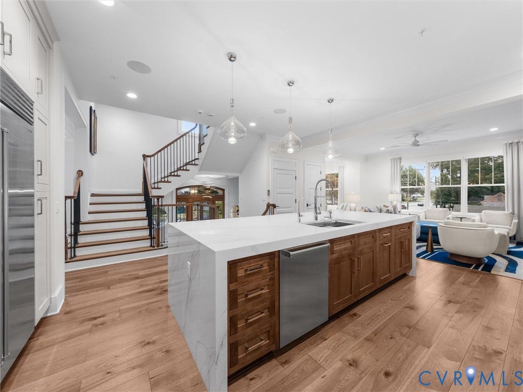 511 Libbie Avenue, #A, The Row At Westhampton, Richmond, VA 23226 Open-concept kitchen with a large island featuring a waterfall-edge countertop, wood-finish cabinetry, and stainless steel appliances