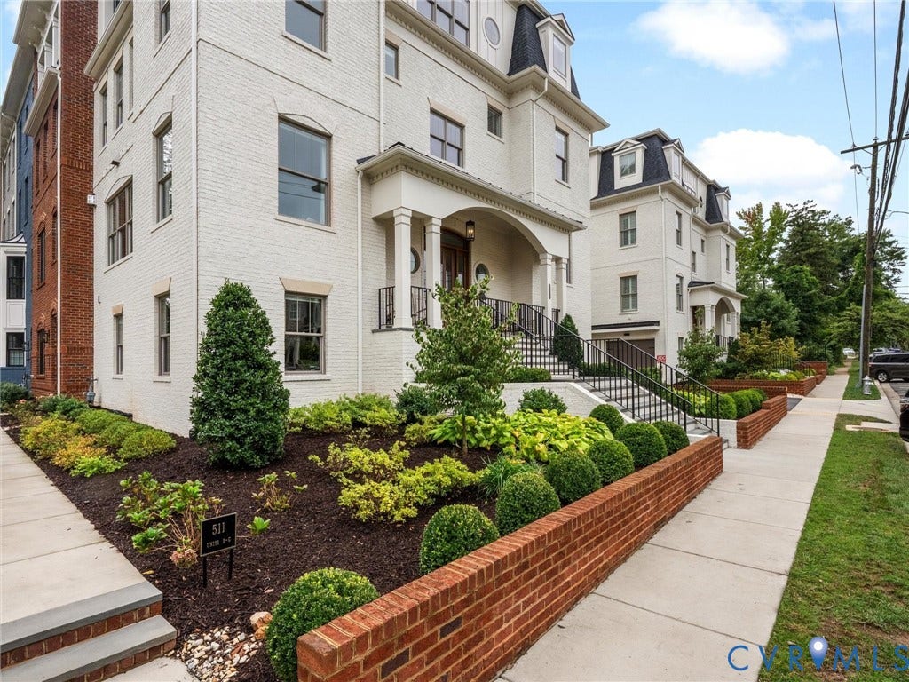 511 Libbie Avenue, #A, The Row At Westhampton, Richmond, VA 23226 White brick exterior with a black mansard roof, arched entry portico, and wrought iron railings