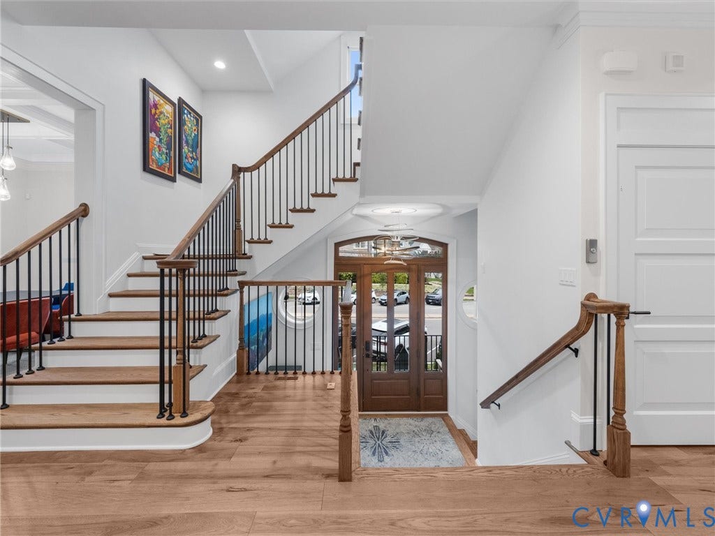 511 Libbie Avenue, #A, The Row At Westhampton, Richmond, VA 23226 Hardwood flooring, wood staircase with black iron spindles, recessed lighting, white panel door, and a decorative front entry door with glass panels
