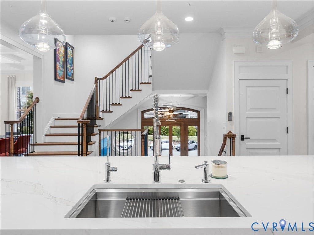 511 Libbie Avenue, #A, The Row At Westhampton, Richmond, VA 23226 Quartz countertop with an undermount stainless steel sink, contemporary pendant lighting, and a grand staircase with dark wood handrails and black balusters