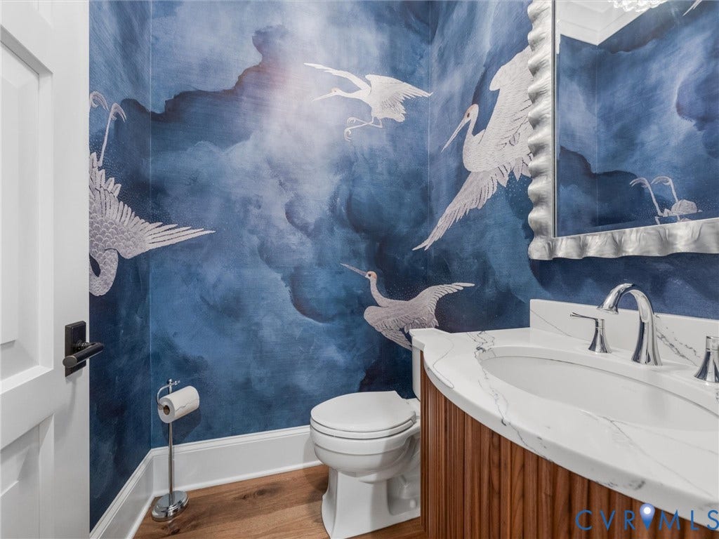 511 Libbie Avenue, #A, The Row At Westhampton, Richmond, VA 23226 Custom wallcovering, wood-finish flooring, half-round vanity with fluted wood-finish cabinetry, countertop with integrated sink, and polished chrome faucet