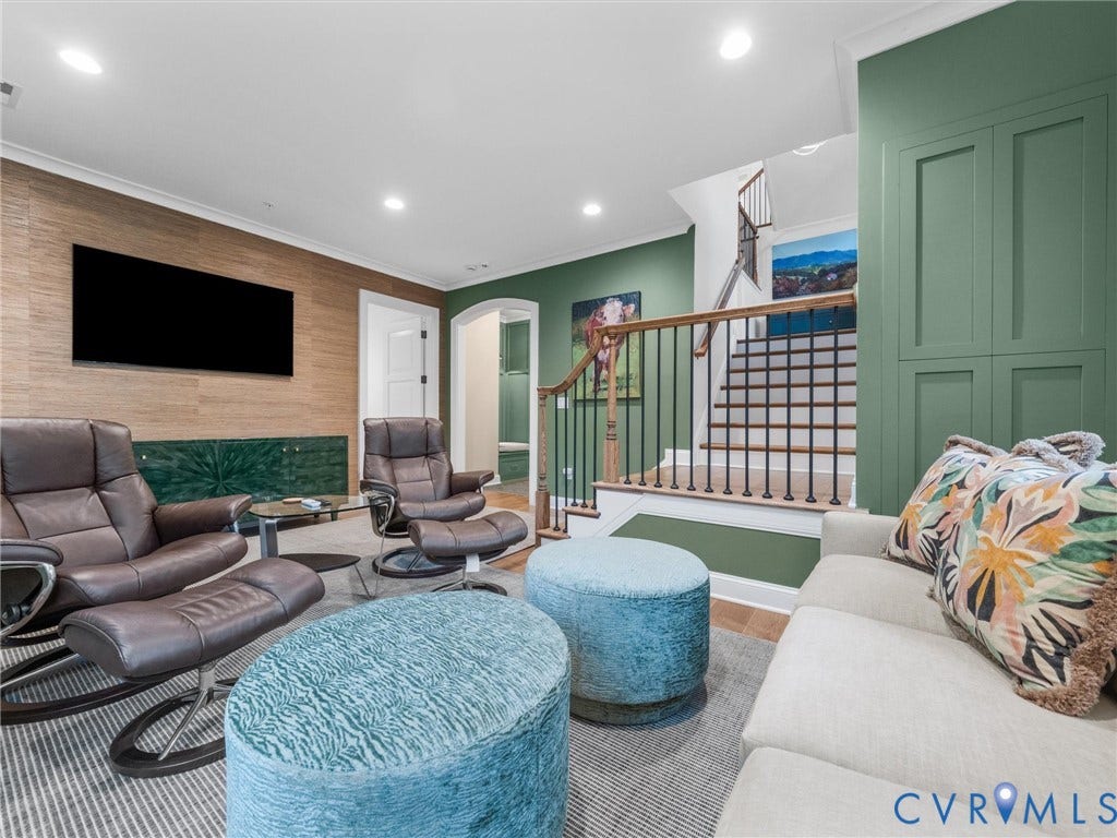 511 Libbie Avenue, #A, The Row At Westhampton, Richmond, VA 23226 Recessed lighting illuminates wood-finish wall paneling, a built-in console, and a staircase with wood treads and wrought iron balusters