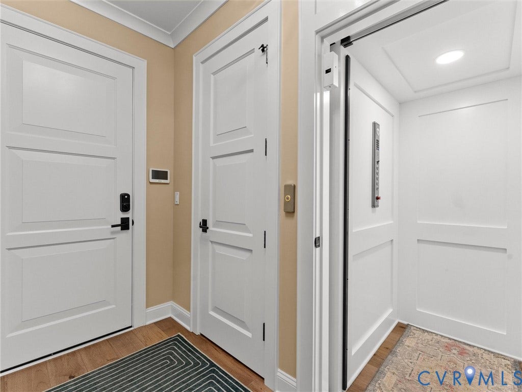 511 Libbie Avenue, #A, The Row At Westhampton, Richmond, VA 23226 Bright entryway showcasing crisp white panel doors with modern hardware, warm neutral wall finishes, and wood-finish flooring