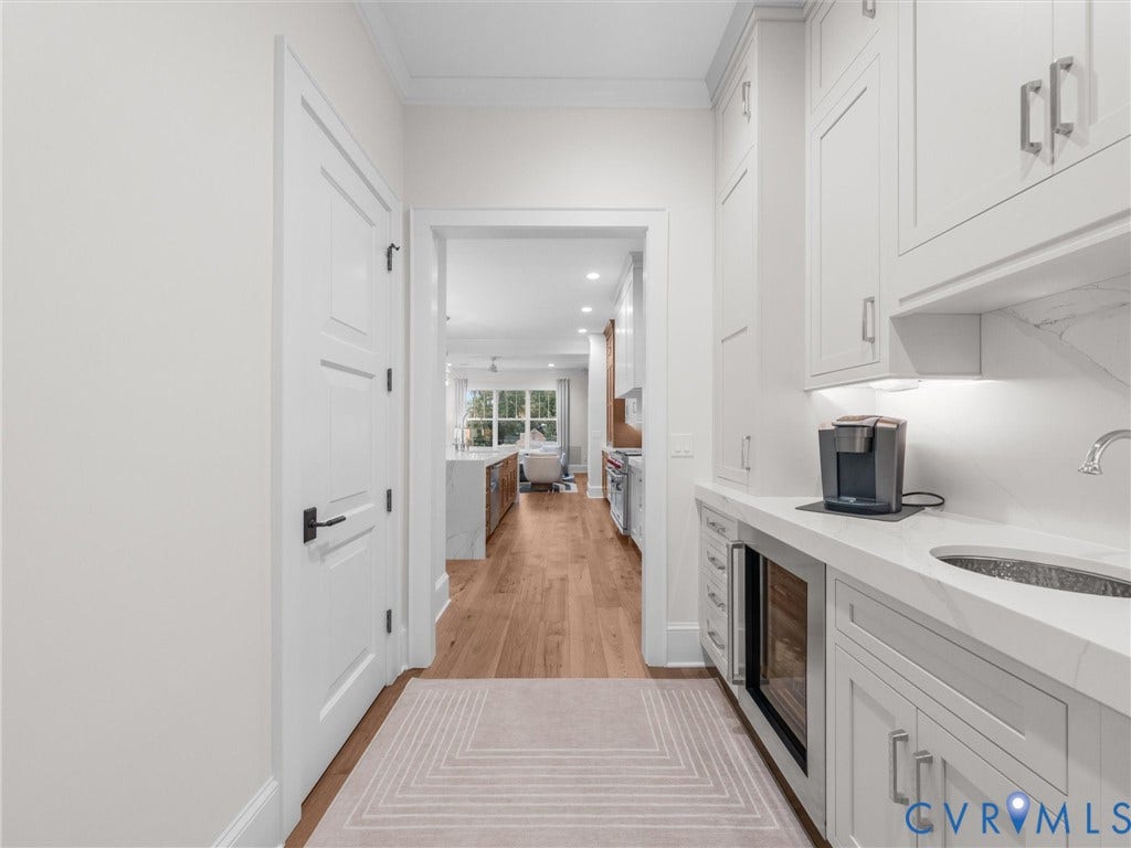 511 Libbie Avenue, #A, The Row At Westhampton, Richmond, VA 23226 White built-in cabinetry with stainless-steel hardware, undermount sink, integrated wine refrigerator, and light wood-finish flooring