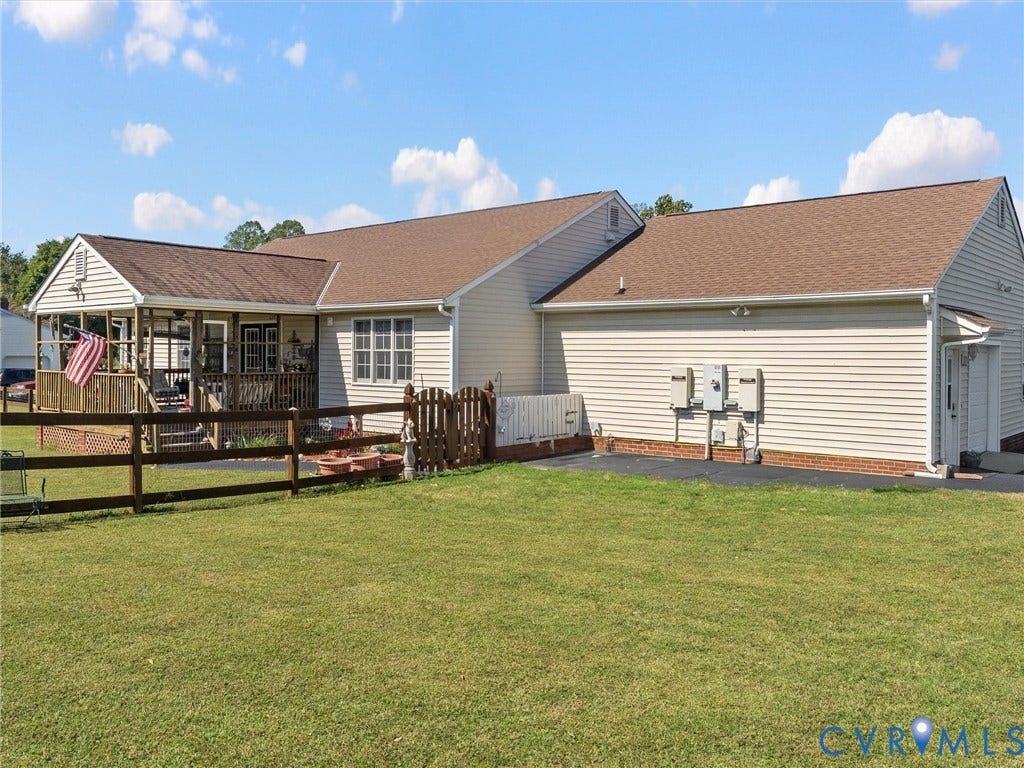 5325 Swift Hill Lane, Scandia Lake, Sandston, VA 23150 Expansive lawn with a wooden split-rail fence, leading to a covered porch with a wood deck