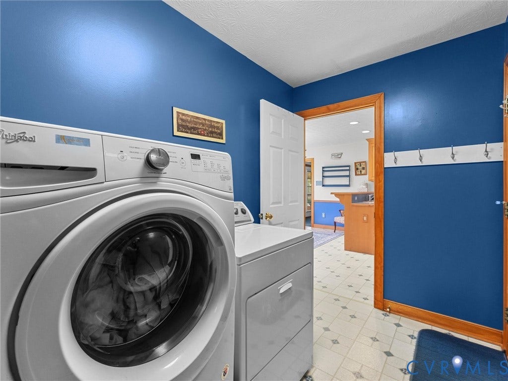 5325 Swift Hill Lane, Scandia Lake, Sandston, VA 23150 Laundry area with a front-load washer and dryer, patterned flooring, and a white coat rack with metal hooks