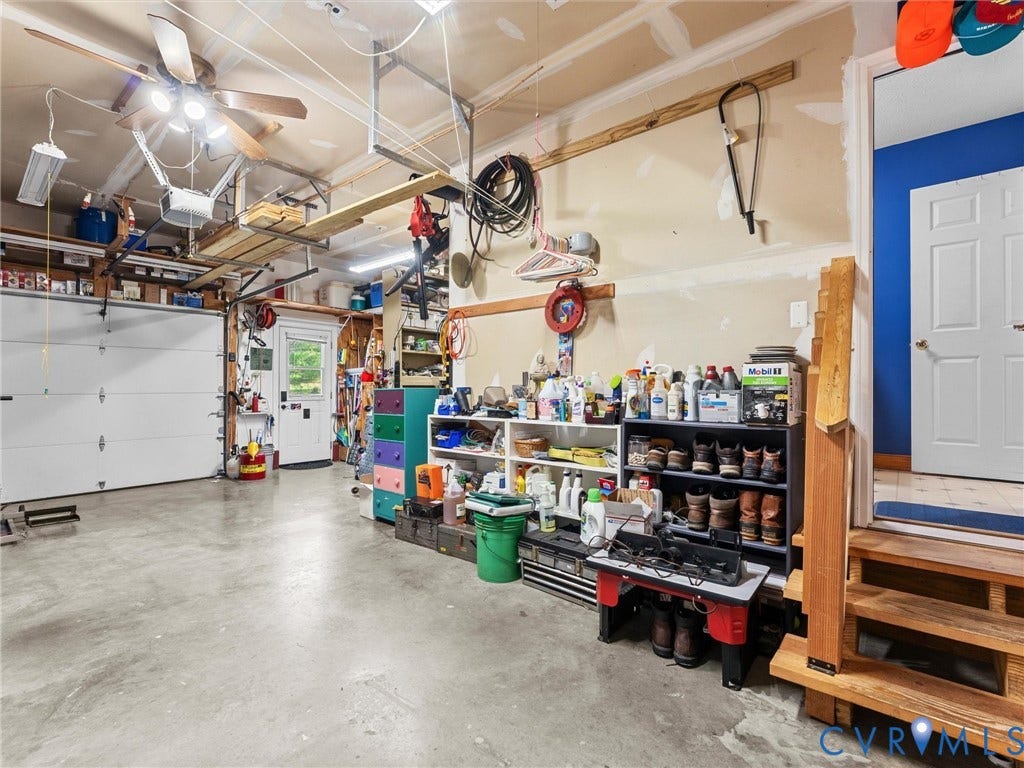 5325 Swift Hill Lane, Scandia Lake, Sandston, VA 23150 Concrete flooring, overhead ceiling fan, white paneled garage door, interior entry door, and wood stairs