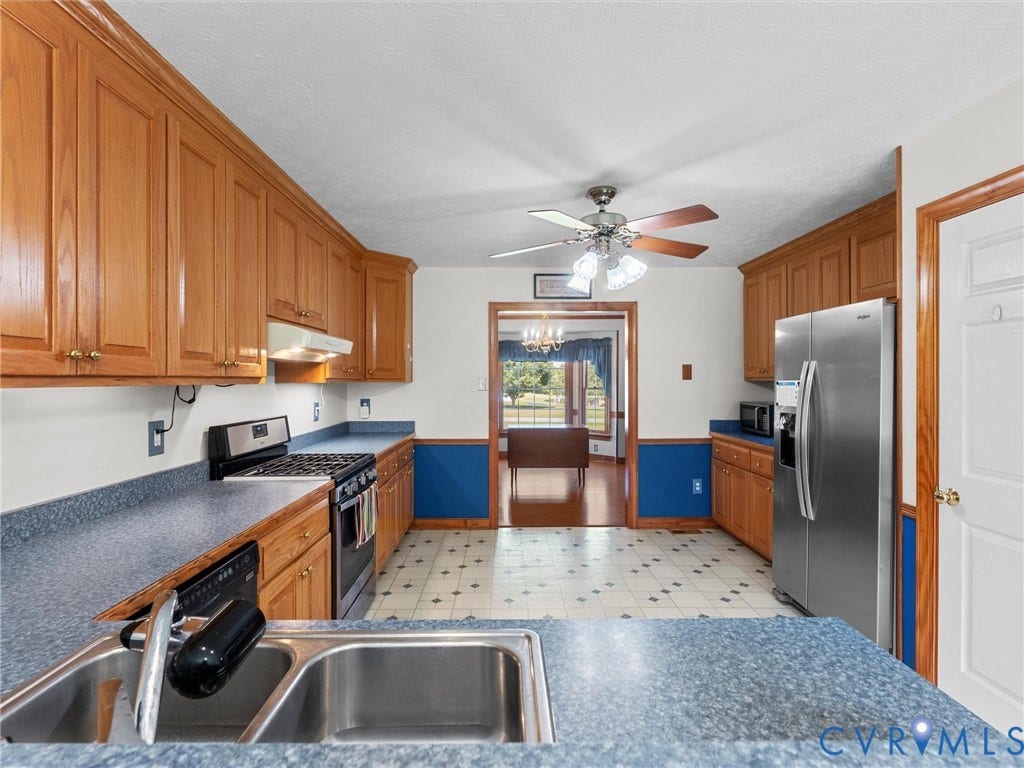 5325 Swift Hill Lane, Scandia Lake, Sandston, VA 23150 Kitchen featuring wood cabinetry, stainless steel appliances, a double basin sink, and patterned floor tile