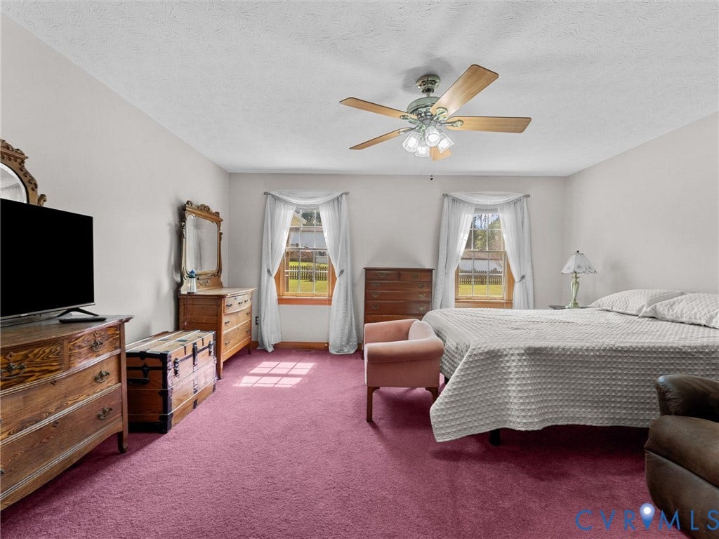 5325 Swift Hill Lane, Scandia Lake, Sandston, VA 23150 Two windows with white draped curtains, a ceiling fan with light fixture, and wall-to-wall carpeting