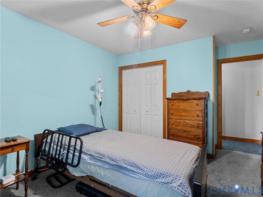 5325 Swift Hill Lane, Scandia Lake, Sandston, VA 23150 Ceiling fan with light fixture, wood-finish trim, white bi-fold closet doors, and carpeted flooring