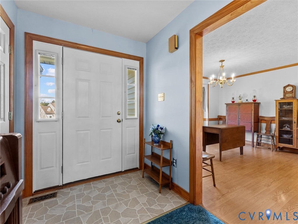 5325 Swift Hill Lane, Scandia Lake, Sandston, VA 23150 Entryway featuring a white paneled front door with sidelights, patterned tile flooring, and wood-finish trim