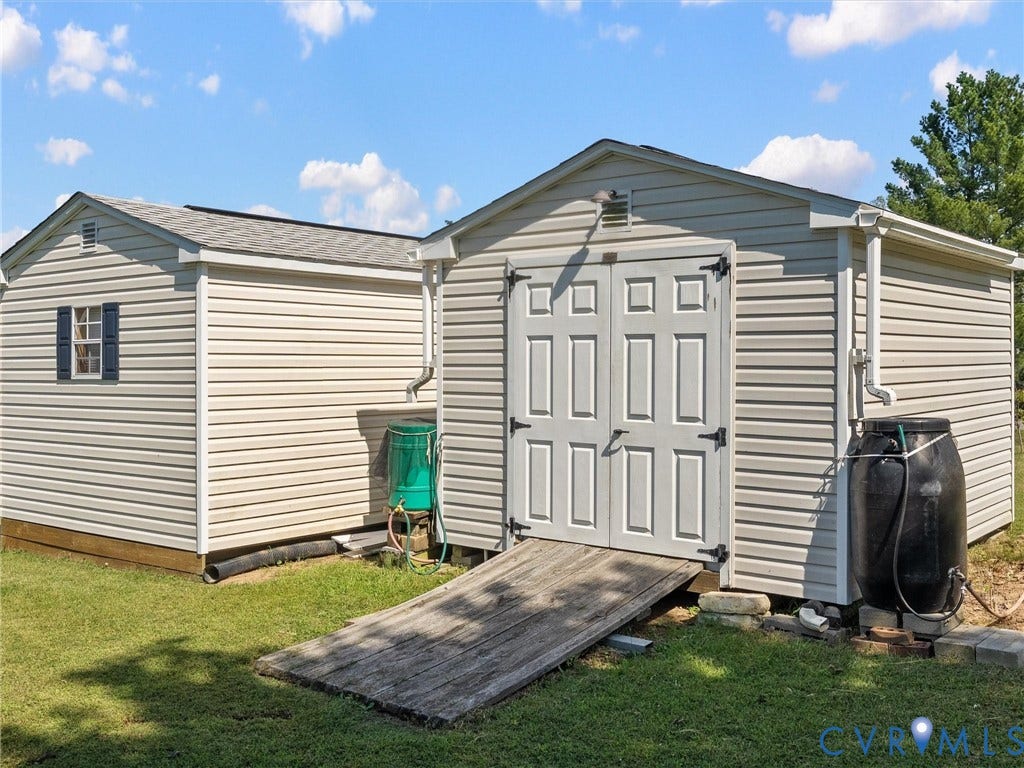 5325 Swift Hill Lane, Scandia Lake, Sandston, VA 23150 Two outdoor storage structures featuring light-colored siding