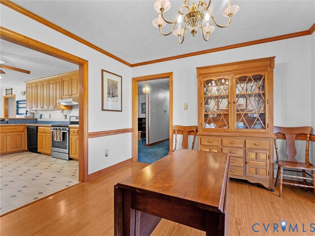 5325 Swift Hill Lane, Scandia Lake, Sandston, VA 23150 Dining area featuring a brass chandelier, wood-finish flooring, and crown molding
