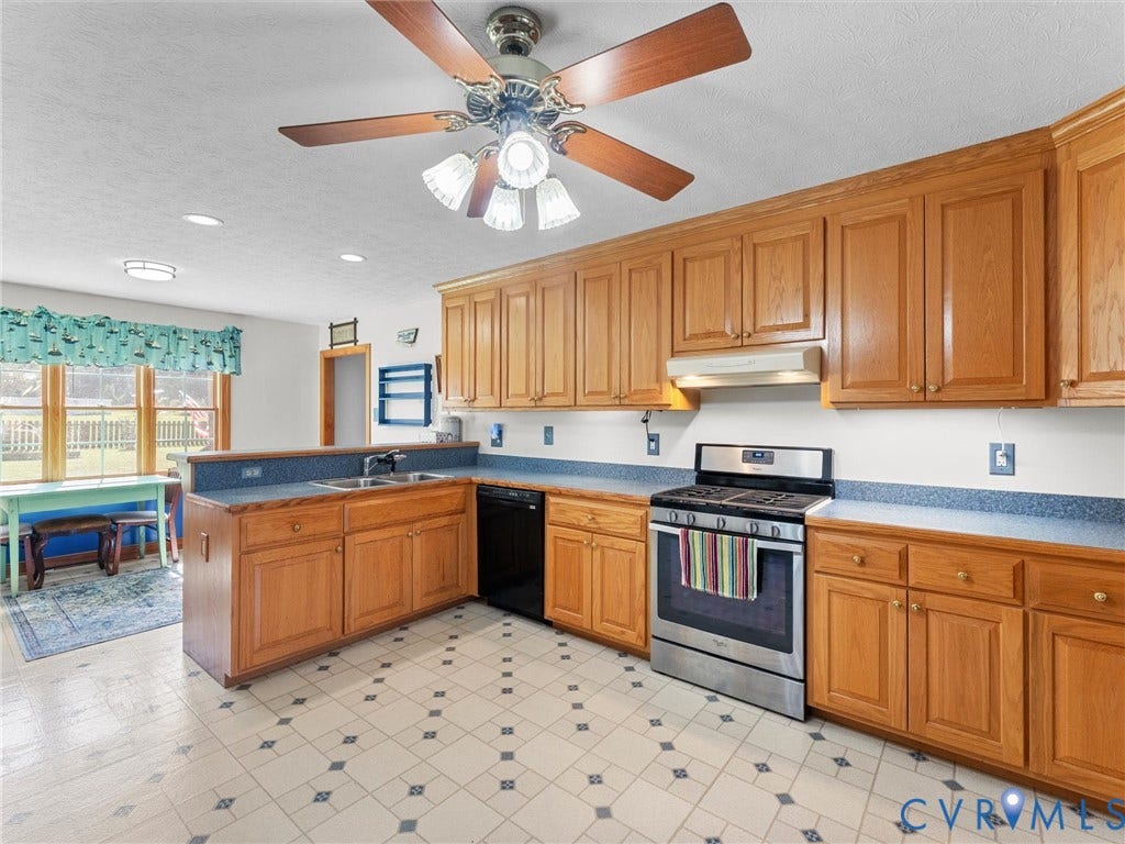 5325 Swift Hill Lane, Scandia Lake, Sandston, VA 23150 Kitchen featuring wood cabinetry, stainless steel range, double basin sink, and patterned floor tile