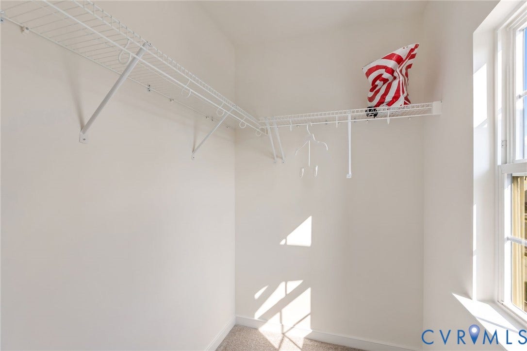 Walk-in closet featuring wire shelving and hanging rods