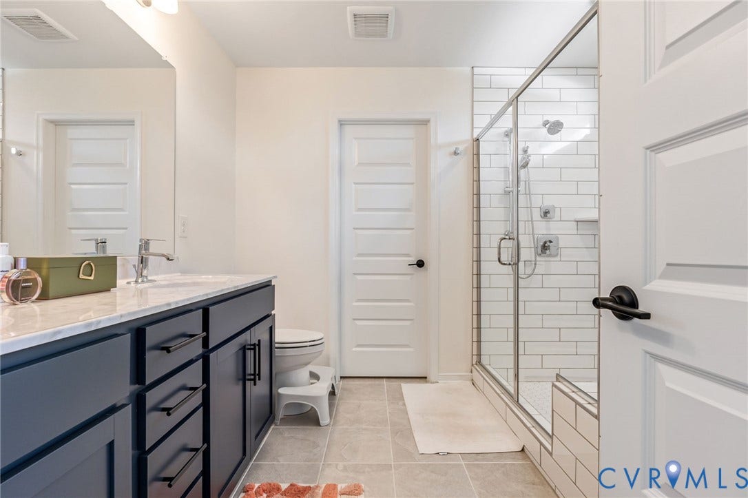 Dual-sink vanity with dark cabinetry and light-toned countertop