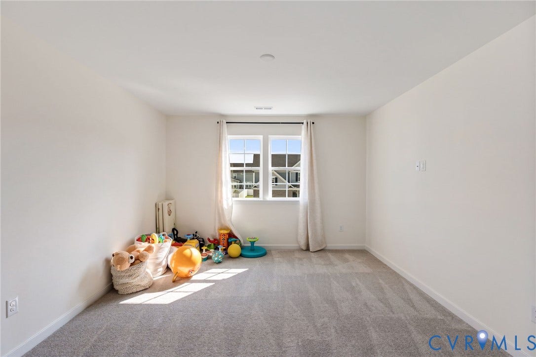 Recessed ceiling lighting, a double-hung window, and gray carpet flooring
