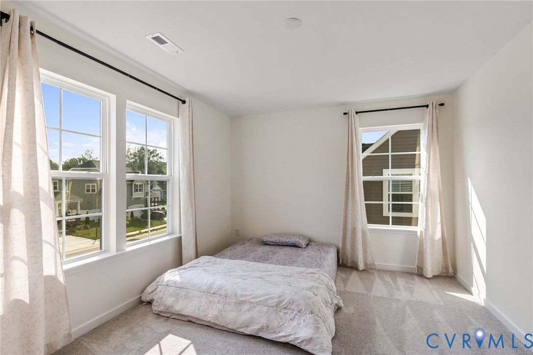 Carpeted room featuring multiple double-hung windows, a recessed ceiling light, and white walls