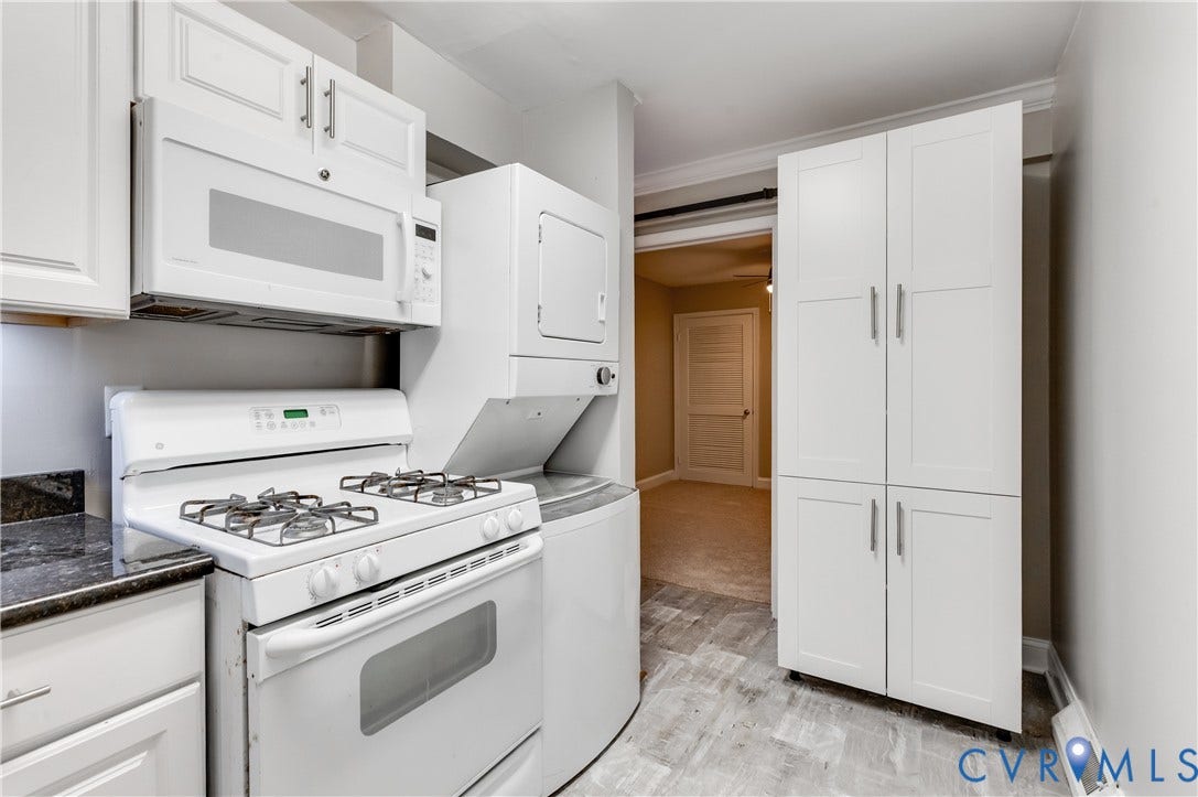 6 Stillwater Lane, Henrico, VA 23228 White cabinetry with brushed nickel hardware, built-in microwave, gas range, stacked washer and dryer, and dark countertop