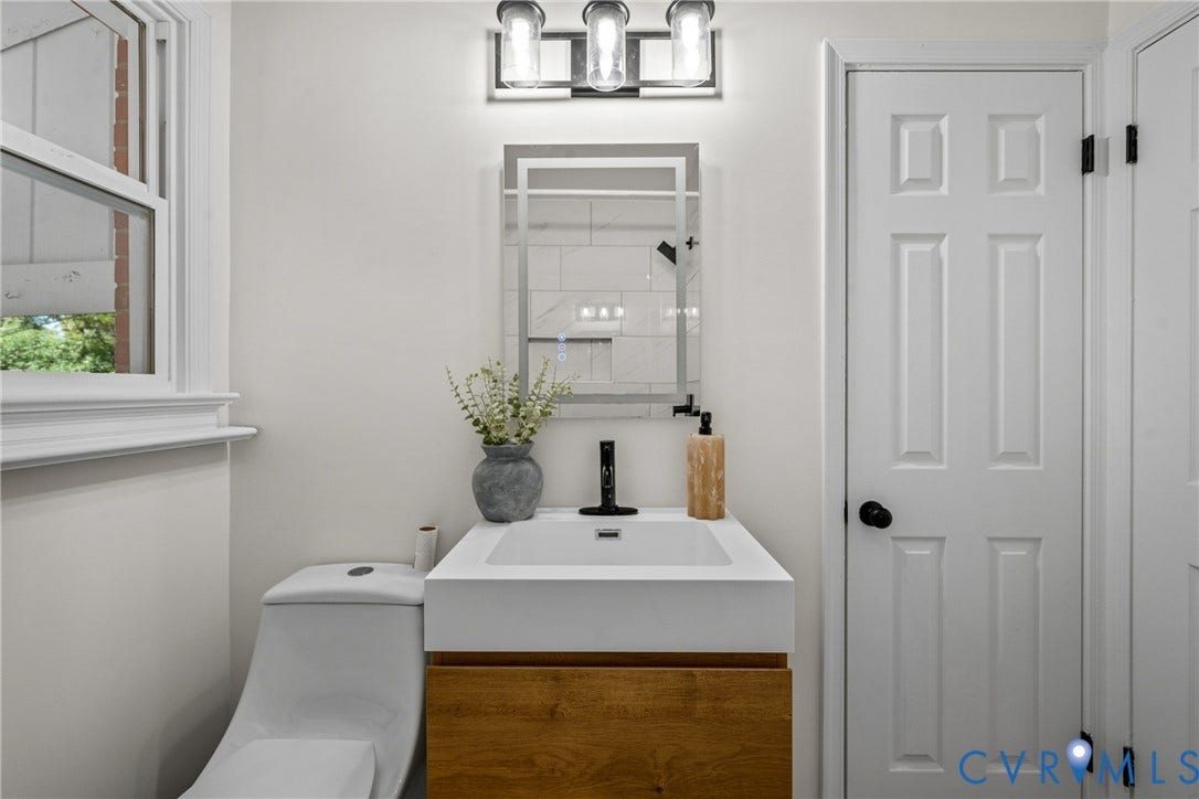 Modern vanity with wood-finish cabinetry, integrated rectangular sink, and matte black faucet