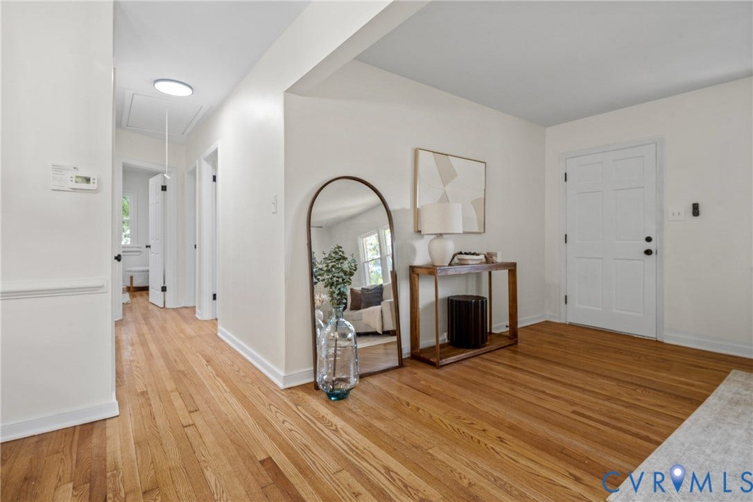 Hardwood flooring throughout, white interior doors, and a skylight in the hallway
