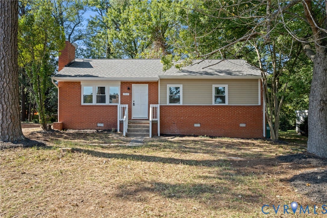 Brick and siding exterior with a white entry door, front porch with white railing, and multiple windows