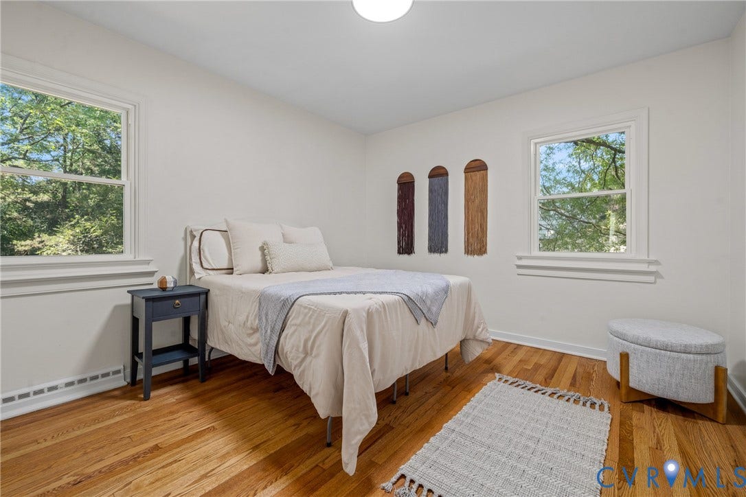 Wood-finish flooring with white trim and dual windows