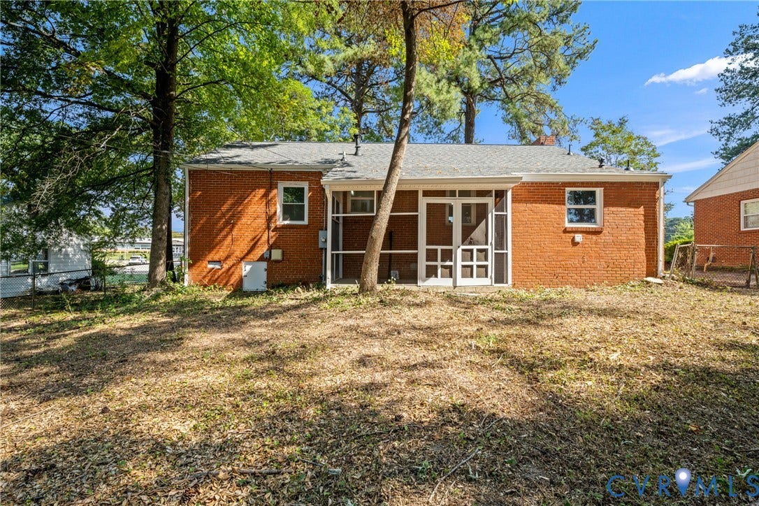 Red brick exterior with white trim windows and a screened-in porch with a white door