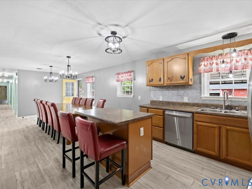 Kitchen featuring wood-finish flooring, wood cabinetry, and a built-in stainless steel dishwasher