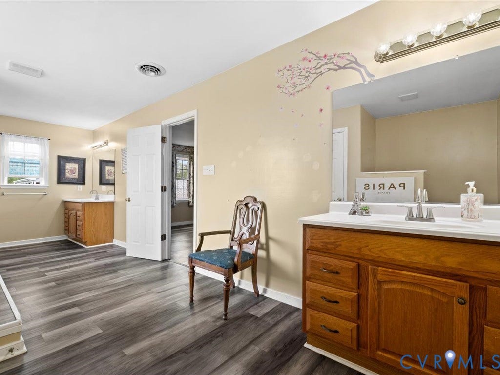 Dual vanity sinks with wood-finish cabinetry and white countertops
