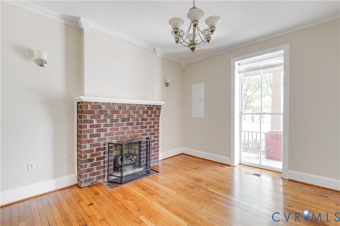 520 N 1st Street, Richmond, VA 23219 Hardwood flooring, brick fireplace with mantel, crown molding, and an attached chandelier