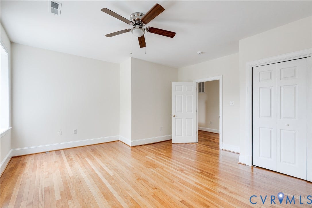 520 N 1st Street, Richmond, VA 23219 Hardwood flooring, painted white walls, ceiling fan with integrated lighting, white bi-fold closet doors, and a white paneled interior door