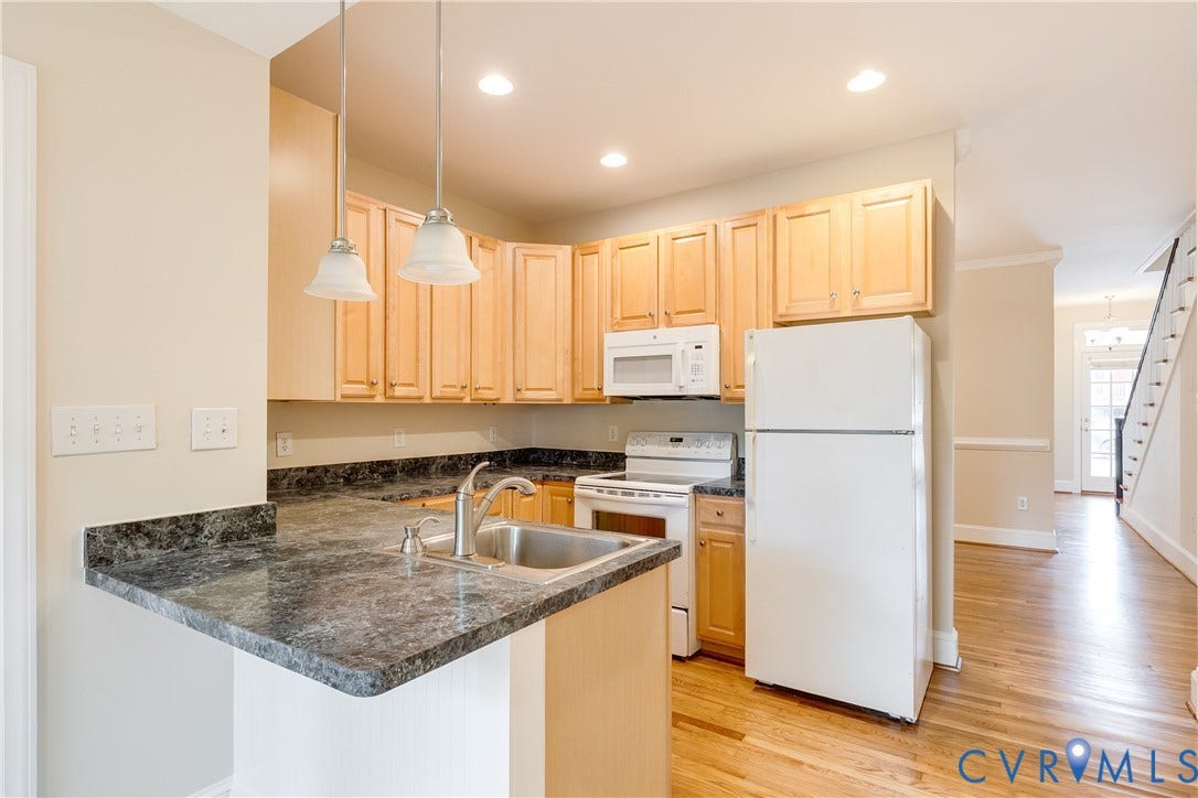 520 N 1st Street, Richmond, VA 23219 Kitchen featuring light wood-finish cabinetry, dark stone-finish countertops, stainless steel sink, and pendant lighting