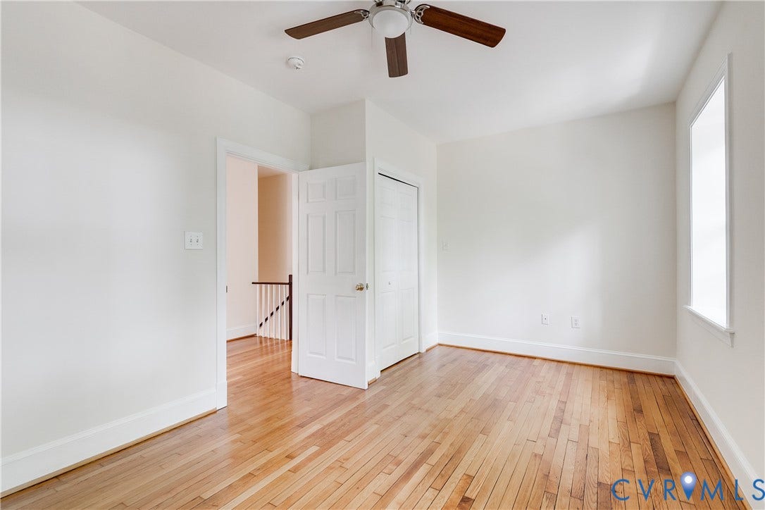 520 N 1st Street, Richmond, VA 23219 Hardwood flooring, painted white walls, ceiling fan, white trim, and a window
