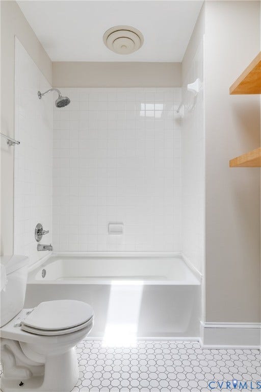 520 N 1st Street, Richmond, VA 23219 White subway tile shower surround with a built-in tub, chrome shower fixtures, and white hexagonal floor tiling