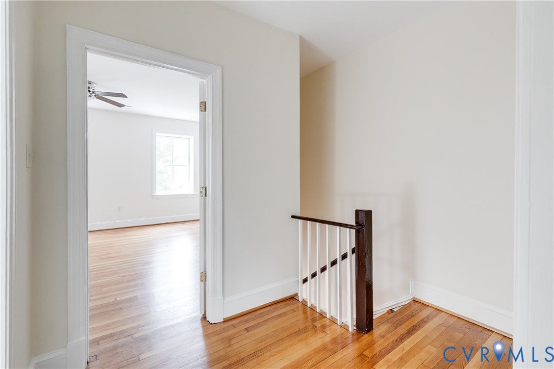 520 N 1st Street, Richmond, VA 23219 Hardwood flooring throughout, white painted walls, white painted trim, staircase with dark wood newel and handrail
