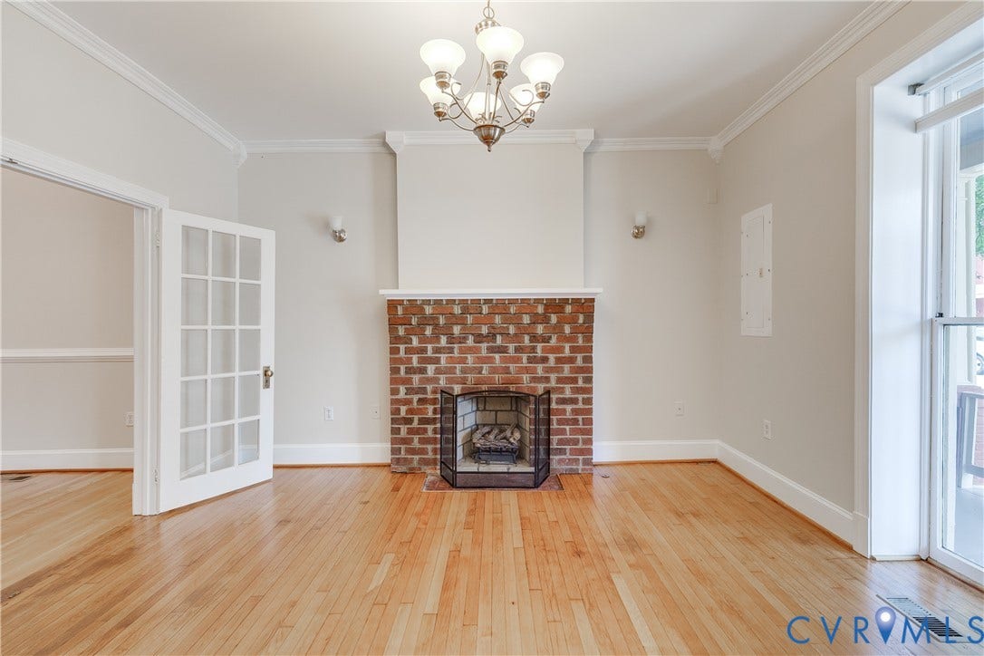 520 N 1st Street, Richmond, VA 23219 Hardwood flooring, crown molding, brick fireplace, glass-paned French doors, and a chandelier