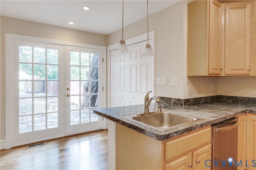 520 N 1st Street, Richmond, VA 23219 Kitchen featuring wood-finish cabinetry, dark countertops, a stainless steel sink, and a stainless steel dishwasher