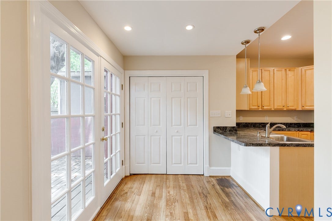 520 N 1st Street, Richmond, VA 23219 Hardwood flooring, kitchen peninsula with dark countertop and stainless steel sink, light wood-finish cabinetry, recessed lighting, and French doors