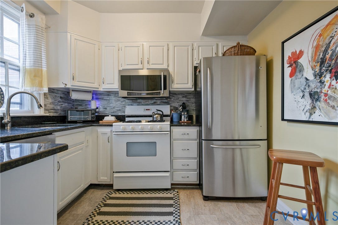 2606 Park Avenue, #U6, The Fan, Richmond, VA 23220 White cabinetry with dark countertops, stainless steel microwave, stainless steel refrigerator, white range, and a tiled backsplash