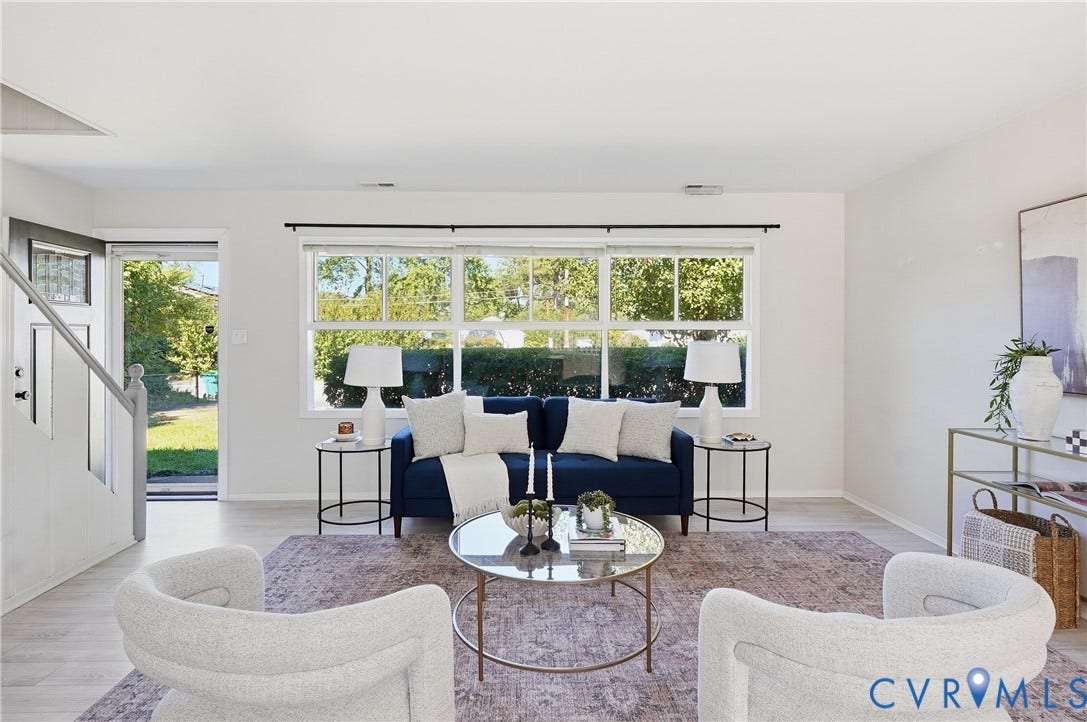 Laminate wood-finish flooring throughout, bright white walls, and a large multi-pane window
