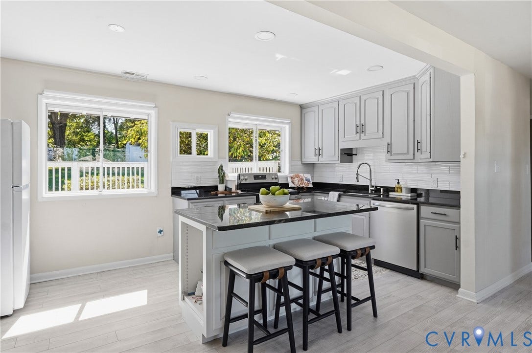 Kitchen featuring a central island, light gray cabinetry, white subway tile backsplash, and light wood-finish flooring