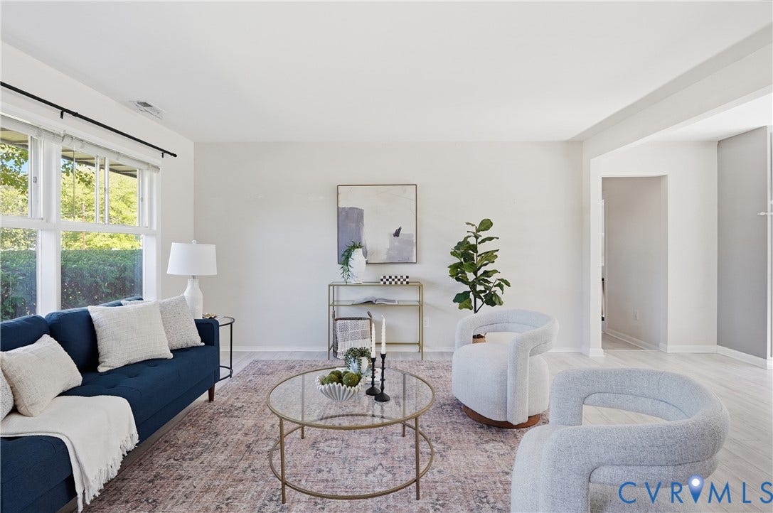 Bright living space featuring large windows, light-toned walls, and light wood-finish flooring
