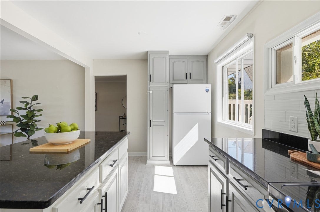 Kitchen featuring white appliances, light gray cabinetry, dark countertops, a white subway tile backsplash, and light wood-finish flooring
