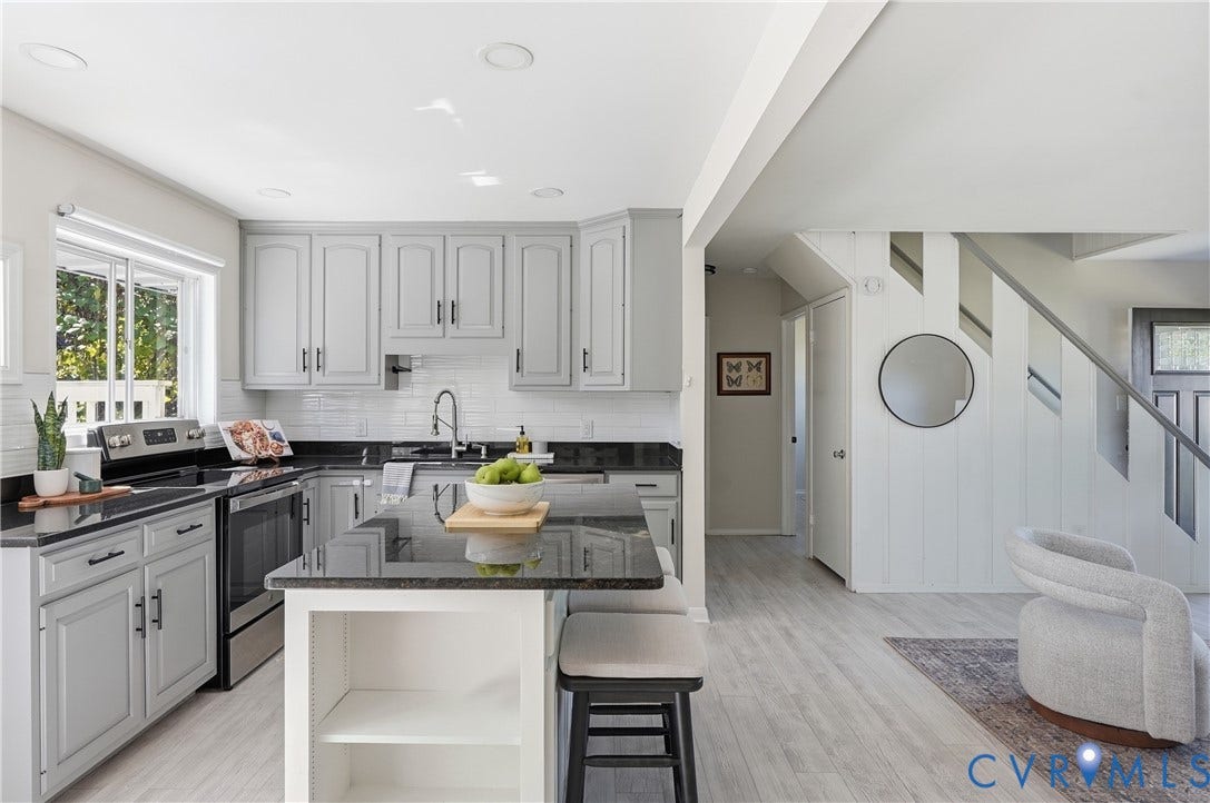Kitchen with light grey cabinetry, dark countertops, white subway tile backsplash, and stainless steel appliances