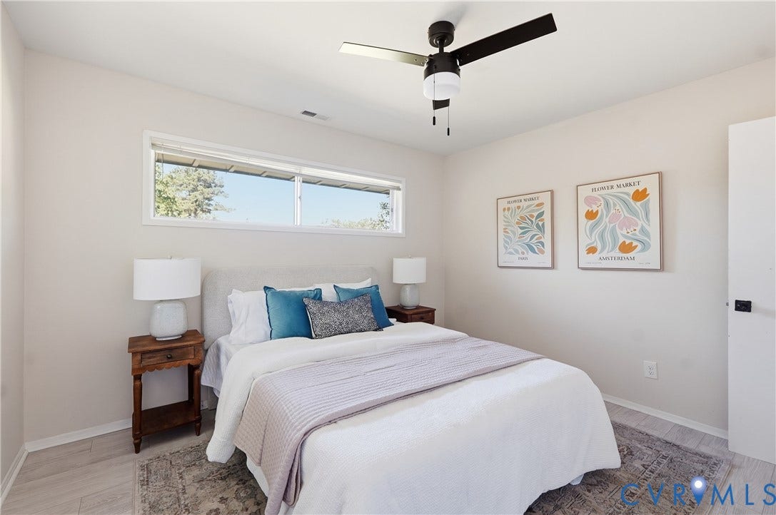 Light wood-finish flooring, a ceiling fan with light, and a high horizontal window