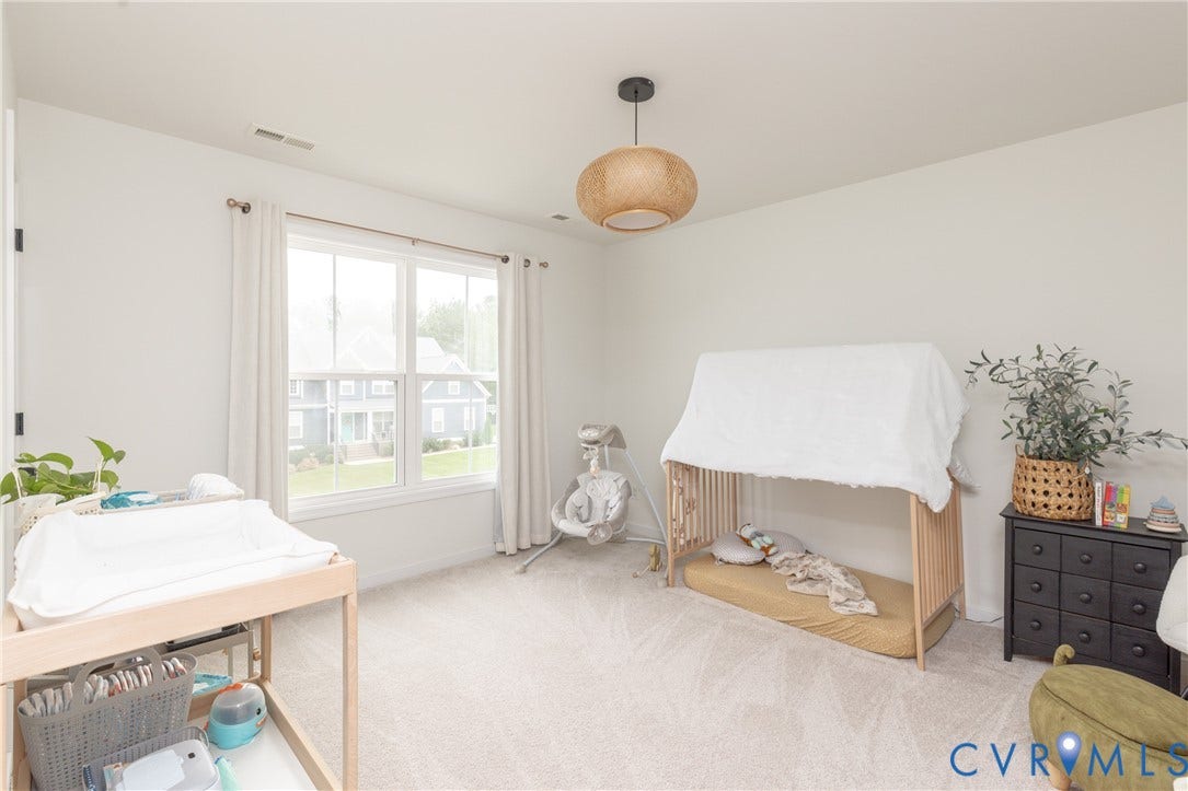 Recessed lighting, large window with natural light, light-toned carpeting, and a modern ceiling fixture