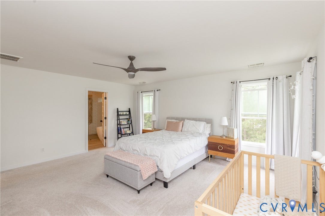 Spacious room featuring light-colored carpeting and a ceiling fan