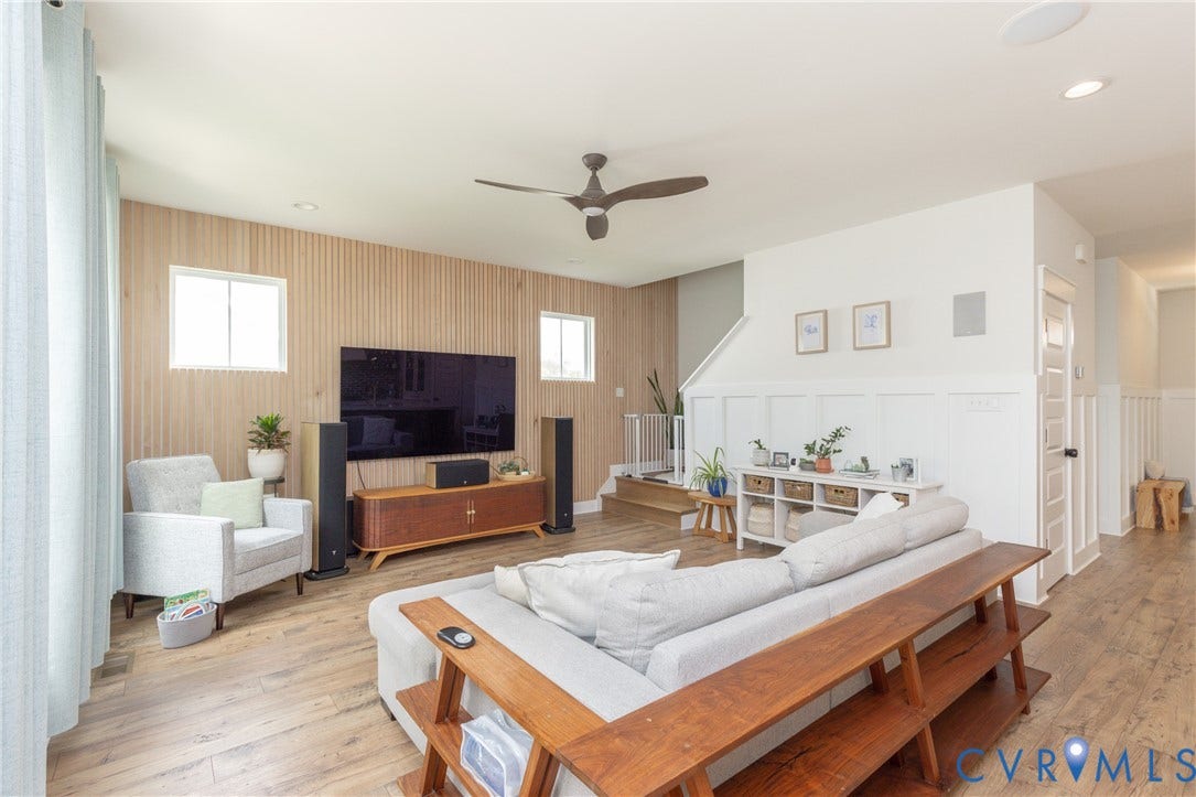 Living area featuring wood-finish flooring, a contemporary ceiling fan, and recessed lighting